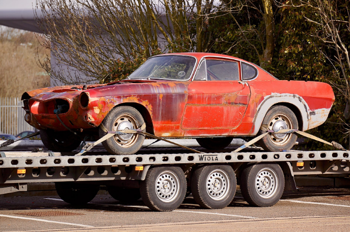 a car is picked up by a flatbed trailer